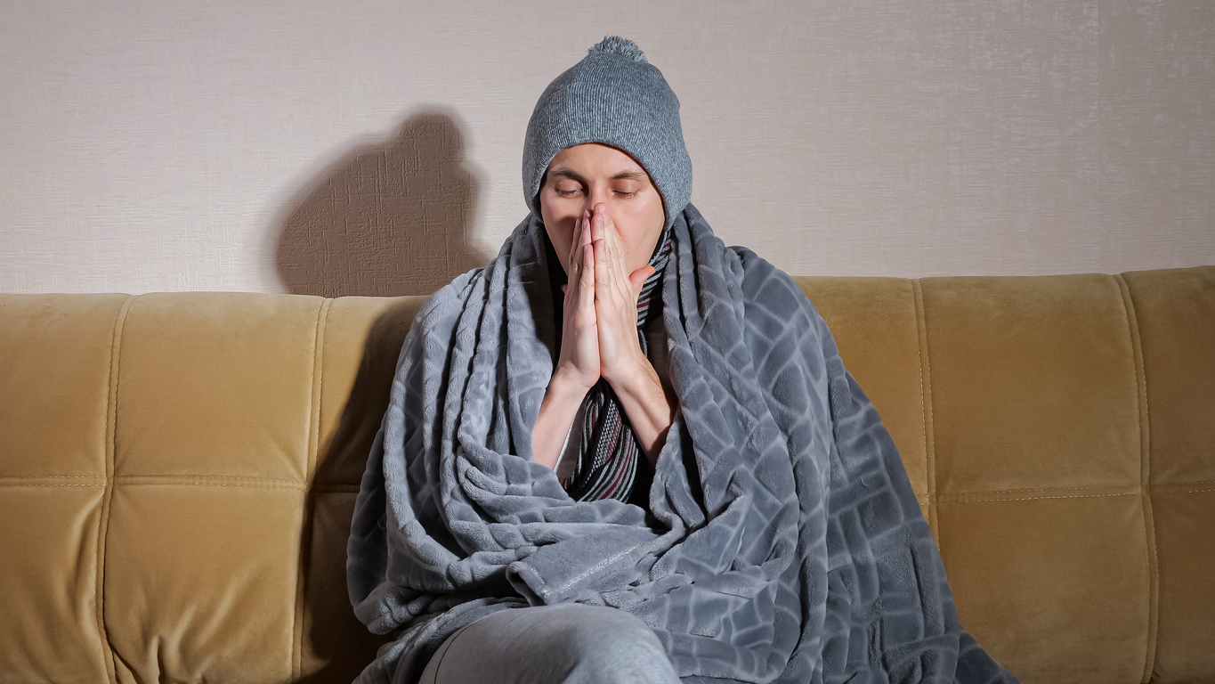 Elderly person cold with blanked on sofa 