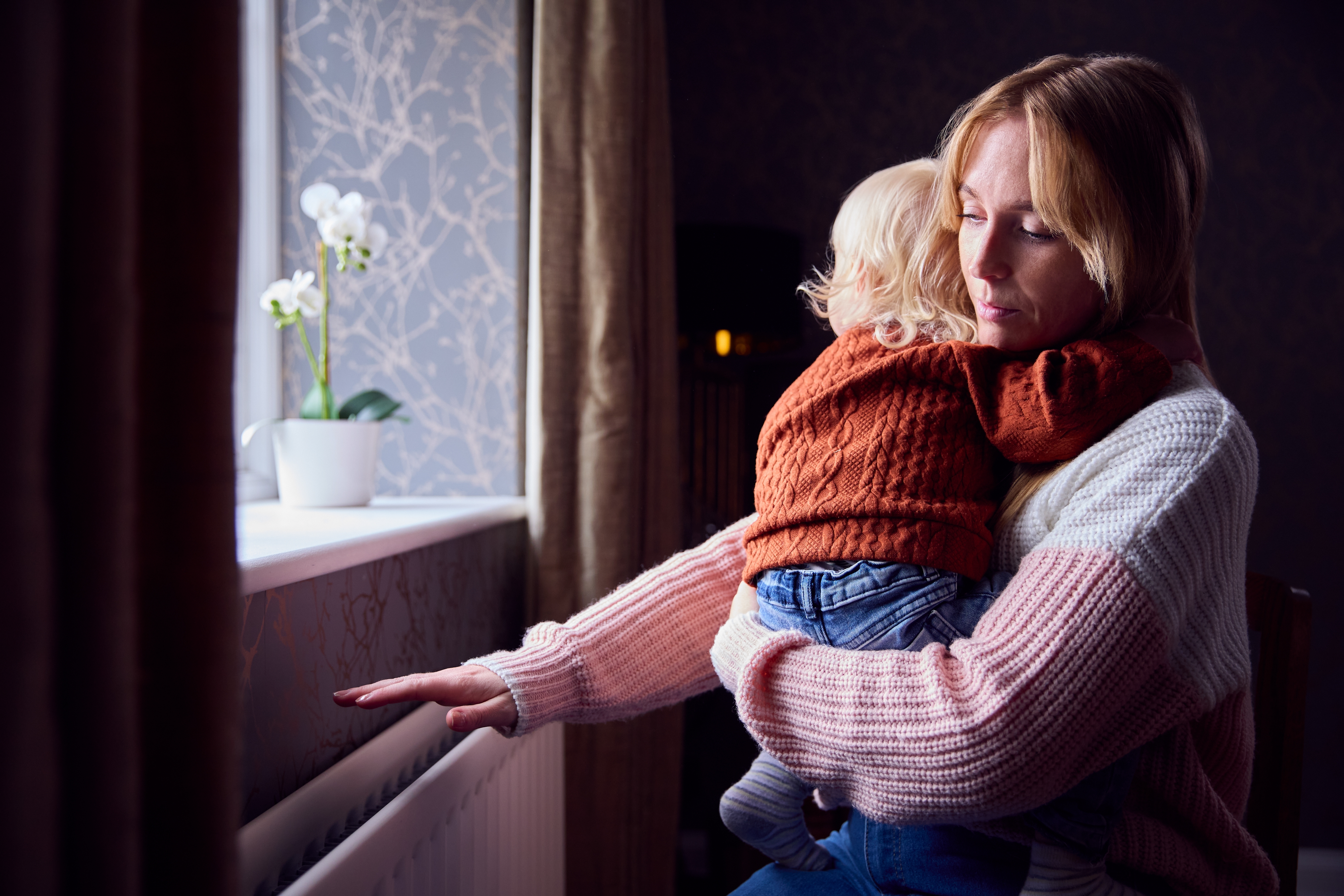 Mother and baby next to a radiator 