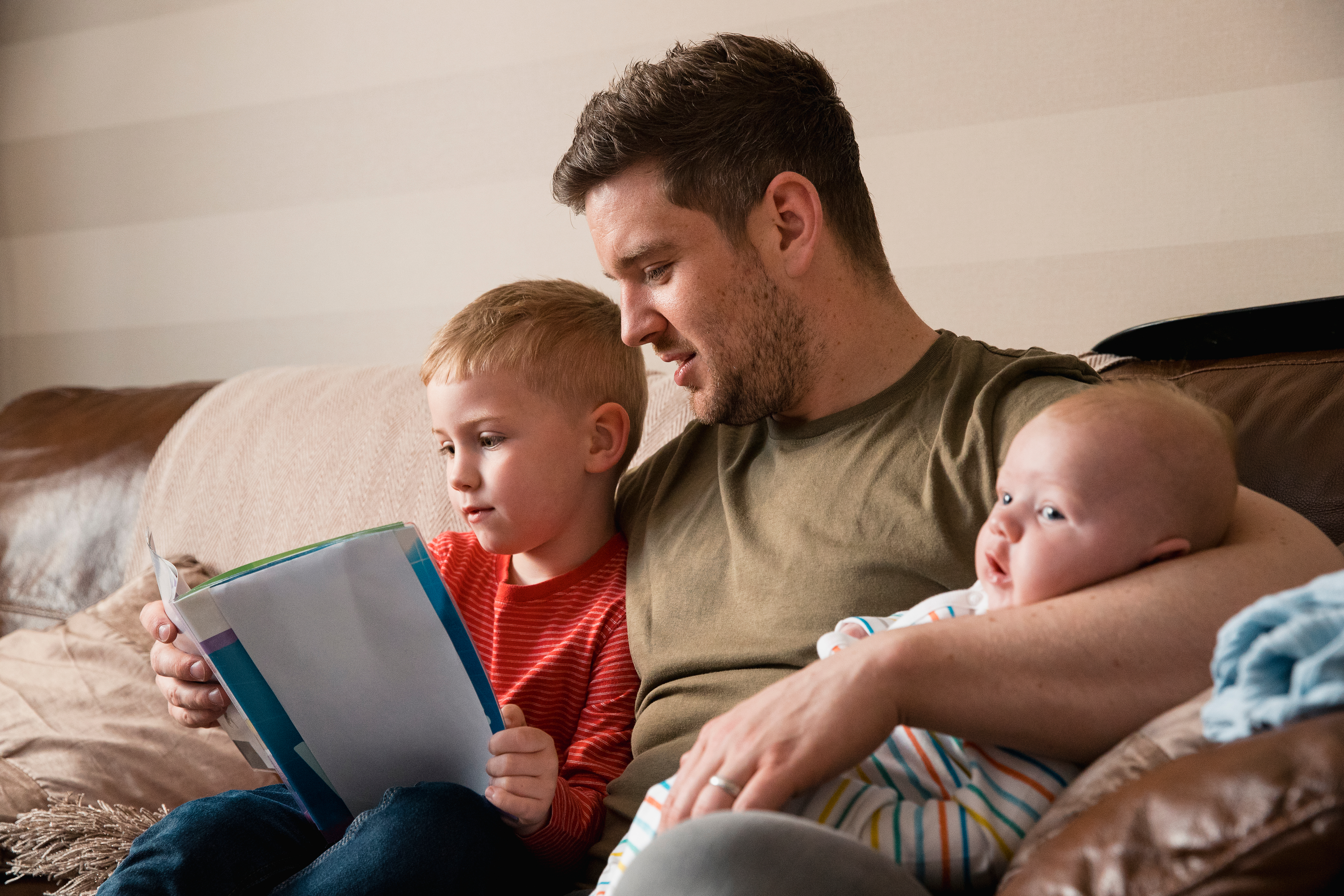 Father with two toddlers on the sofa.