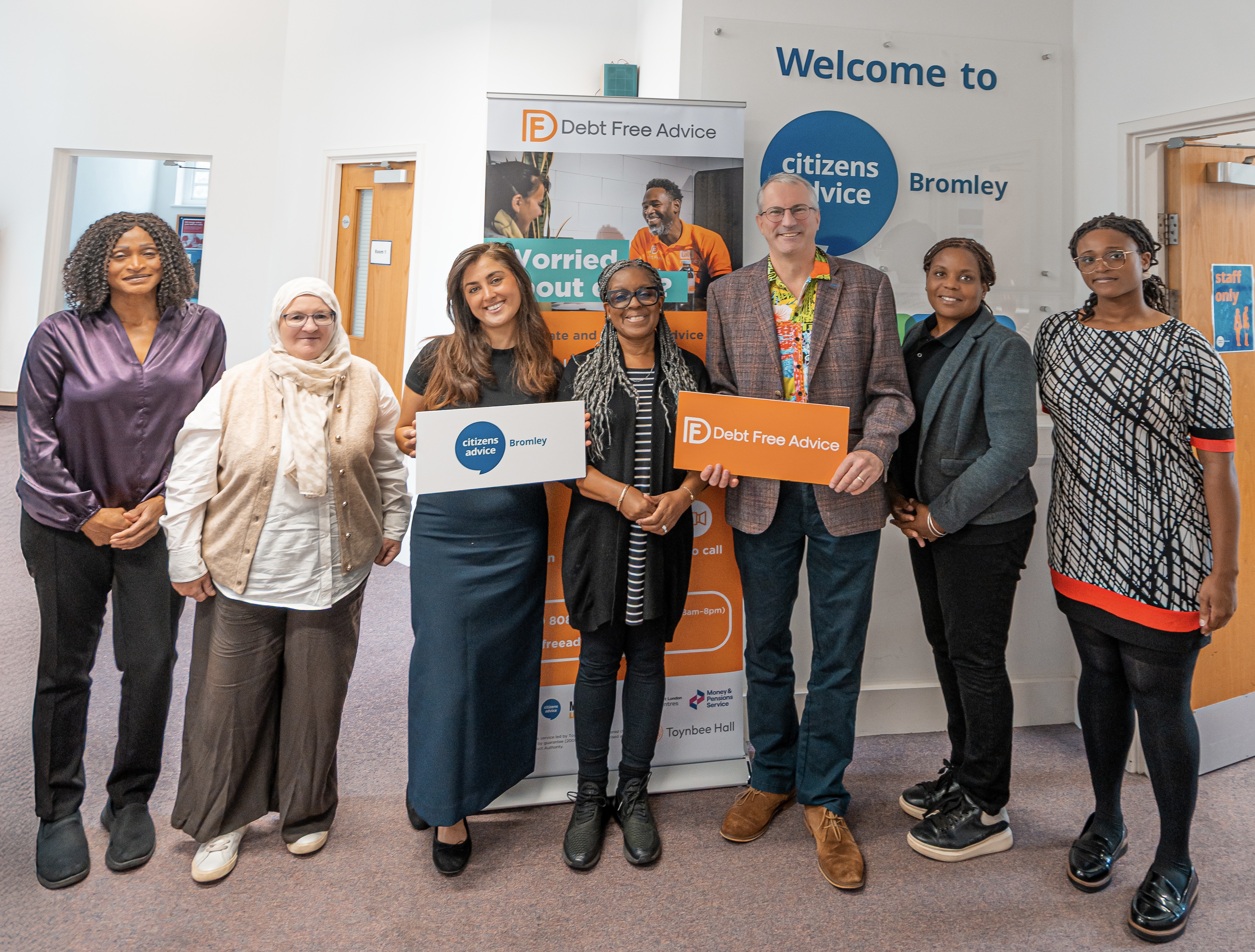 People standing in front of banner inside advice centre