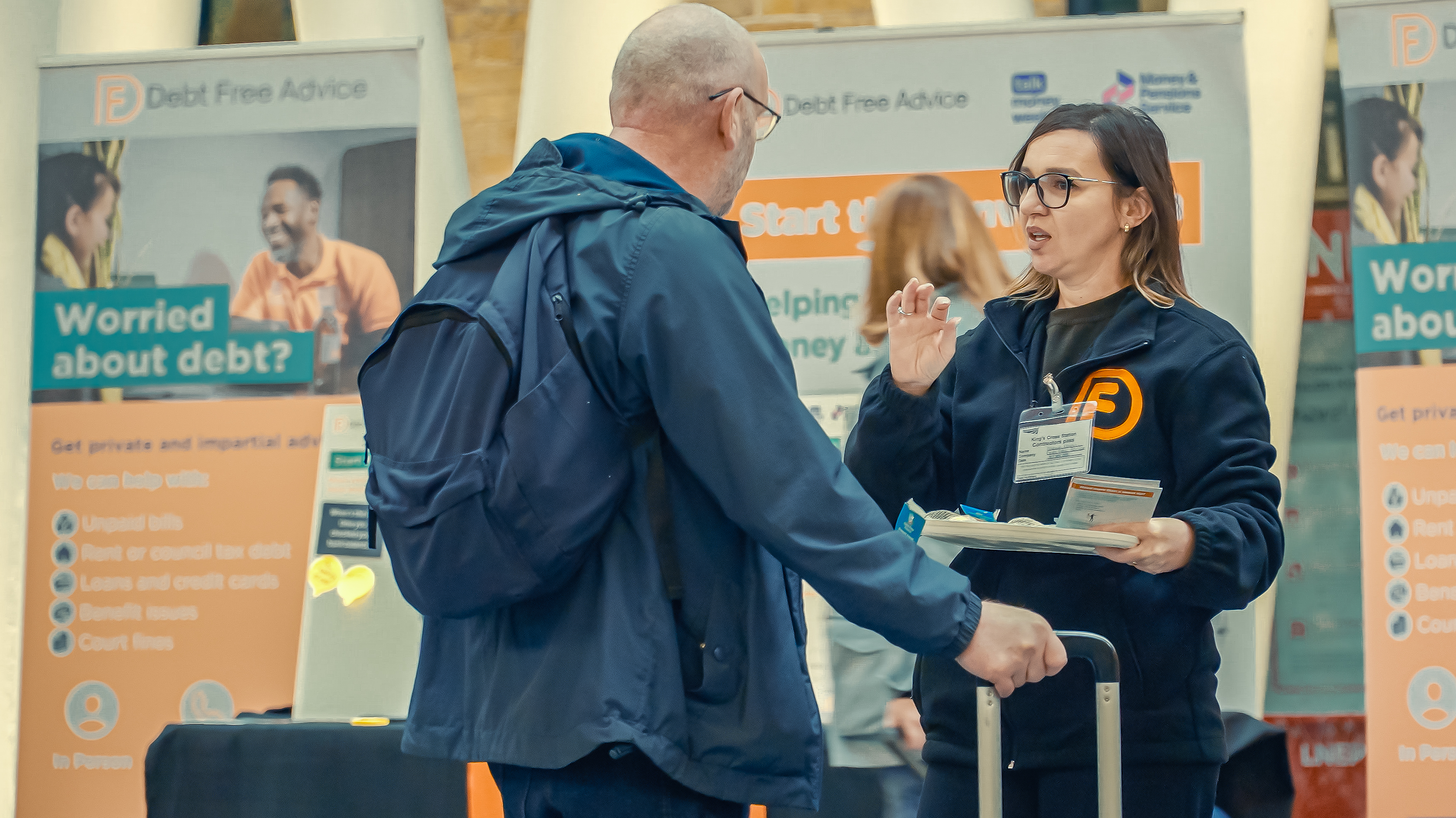 An advisor speak with a commuter in Kings Cross station