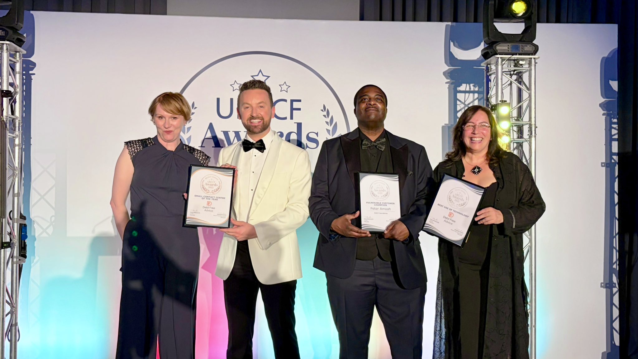 Four representatives from Debt Free Advice on the stage receiving awards